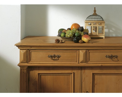 Kommode aus Holz mit Schubladen, darauf Obstschale und Vogelkäfig