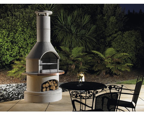 Gemauerter Gartengrill mit Holzlagerfach, Tisch und Stühlen im Garten