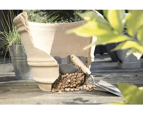 Beschädigter Pflanztopf aus Terrakotta mit Blähton und Pflanzschaufel