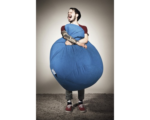 Mann umarmt einen blauen Sitzsack im Innenraum