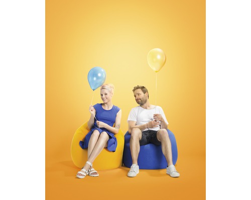 Ein Mann und eine Frau sitzen auf Sitzsäcken mit Luftballons.