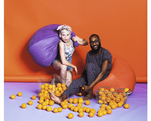 Zwei Personen, eine mit einem Sack und eine auf einem Sitzsack, umgeben von Bällen.