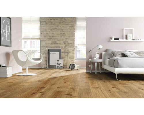 Helles Schlafzimmer mit Holzboden, Sessel und Bett