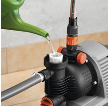 Gartenpumpe wird mit einer Gießkanne befüllt