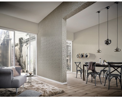 Wohnzimmer mit Tapete, Esstisch und Stühlen, sowie einer Sitzecke mit Sessel