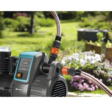 Gartenpumpe mit angeschlossenen Gartenschläuchen im Außenbereich