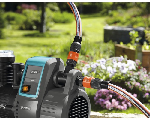 Gartenpumpe mit angeschlossenen Gartenschläuchen im Außenbereich