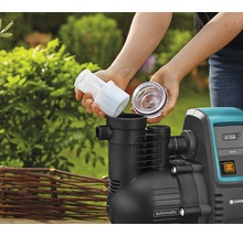 Frau setzt Filter in eine Gartenpumpe ein.