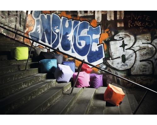 Mehrere Sitzwürfel auf Treppen vor einer Wand mit Graffiti