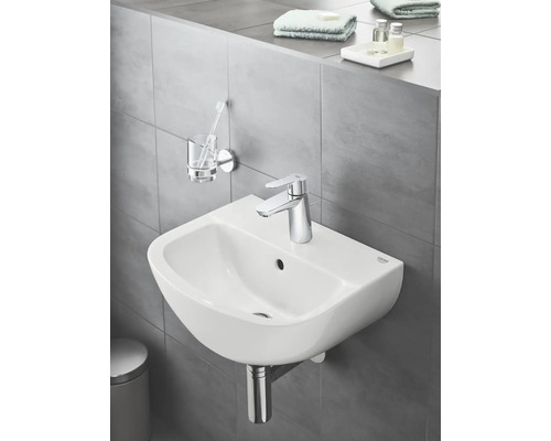 Keramikwaschtisch mit Armatur und Accessoires im Badezimmer