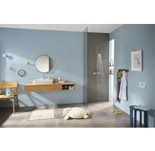 Badezimmer mit Dusche, Waschtisch, Spiegel und Accessoires in hellem Design
