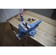 Blauer Schraubstock mit Kette auf einer Holzoberfläche