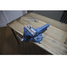 Blaue Werkbank mit Schraube und Muttern auf Holztisch