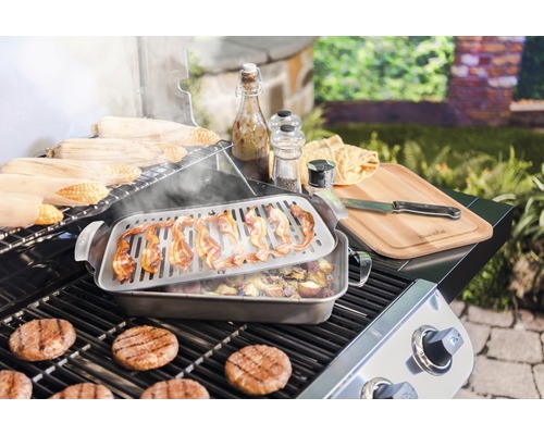 Grillszene mit Burgern, Speck, Maiskolben, Kartoffeln, Schneidebrett und Gewürzen.