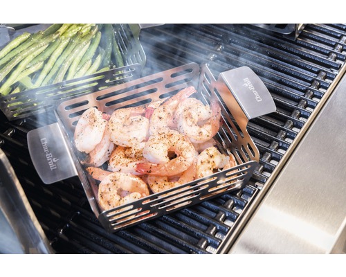 Gegrillte Garnelen in einer Grillpfanne mit Gemüsespießen auf einem Grill.