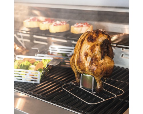 Gegrilltes Hähnchen auf einem Getränkehalter mit Gemüse und Brotscheiben im Hintergrund.