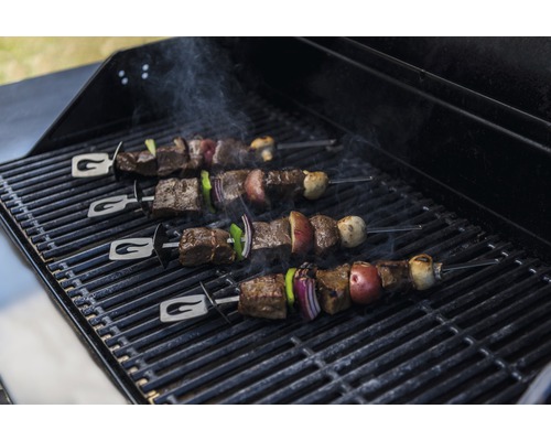 Grill mit vier Fleischspießen und Gemüse