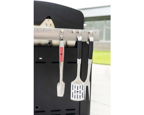 Grillbesteck an einem Grill befestigt, inklusive Zange, Wender und Gabel