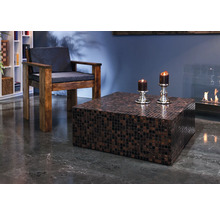 Wohnzimmer mit Sessel, quadratischem Mosaiktisch und Kamin