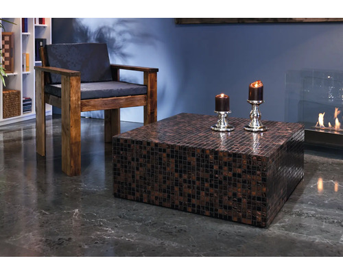 Wohnzimmer mit Sessel, quadratischem Mosaiktisch und Kamin