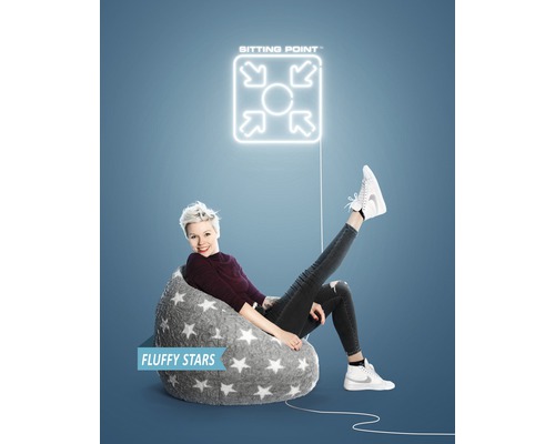 Frau sitzt in einem grauen Sitzsack mit Sternenmuster unter einem ''Sitting Point'' Logo