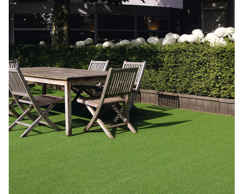 Gartenszene mit Kunstrasen, Holztisch und Stühlen