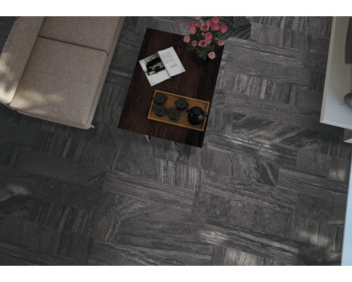 Blick von oben auf ein Wohnzimmer mit Fliesenboden, Sofa und Couchtisch