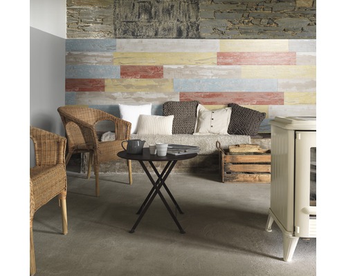 Kunststoffpaneel Element Compact Cabane natur 6x154x1200 mm Gemütlicher Wohnbereich mit Wandpaneelen in Holzoptik, Korbstühlen, einem runden Tisch und einem Ofen