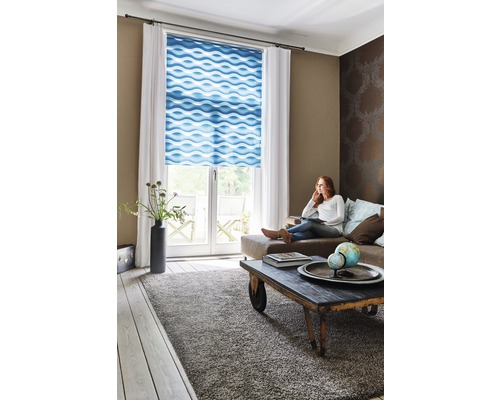 Wohnzimmer mit Frau auf Couch, Rollos mit Wellenmuster und Teppich