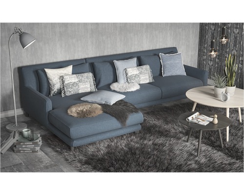 Wohnzimmer mit Ecksofa, Kissen, Teppich und Couchtischen