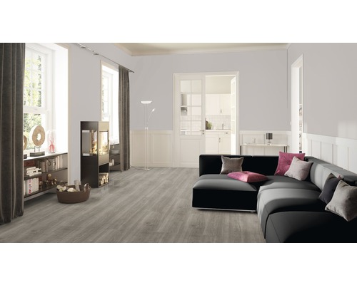 Wohnzimmer mit grauem Vinylboden, schwarzem Sofa und Kaminofen