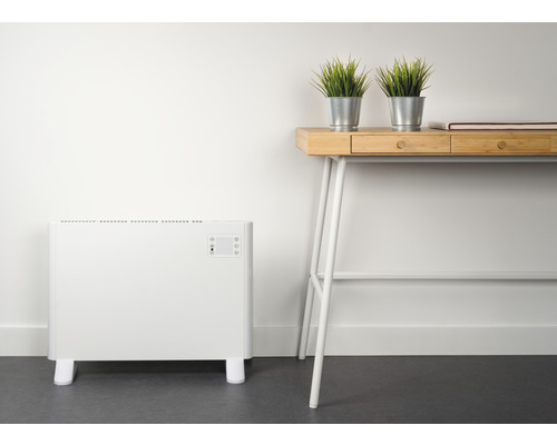 Weißer Heizkörper neben Schreibtisch mit Dekoration