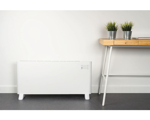 Elektrischer Heizkörper neben einem Schreibtisch mit Dekoration