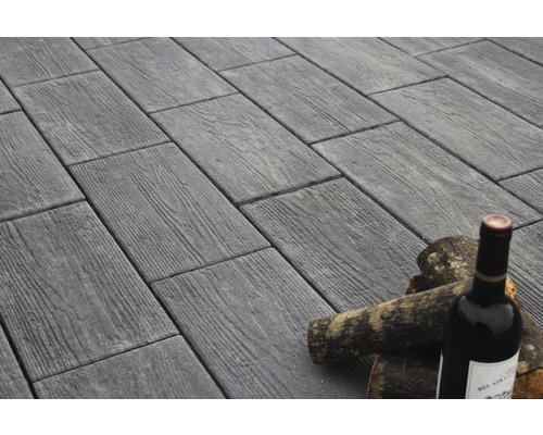 Pflastersteine in Holzoptik mit Weinflasche und Holzscheiten