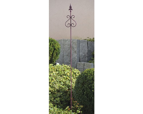 Gartenstecker aus Metall mit dekorativem Muster in einem Gartenbeet.
