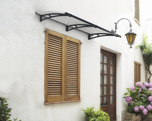 Fassade eines Hauses mit einer Türüberdachung, Fensterläden und Außenbeleuchtung