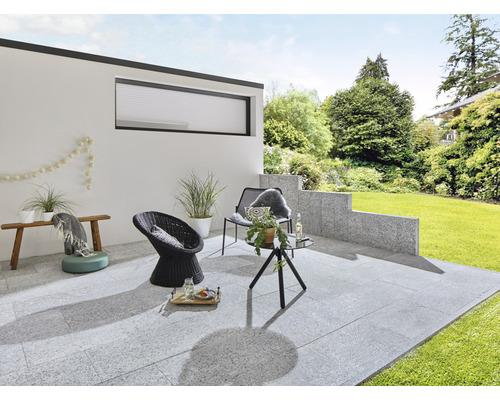 Terrasse mit Gartenmöbeln und Steinfliesen