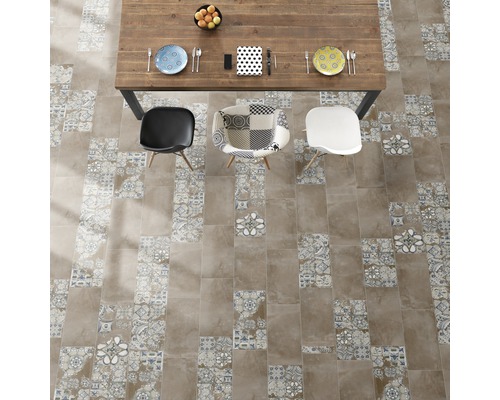 Ansicht von oben auf einen Esstisch mit Stühlen auf Fliesenboden mit Mustern.