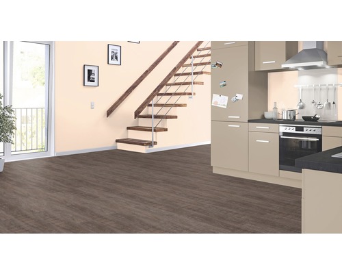Wohnraum mit Treppe, Tür, Küchenzeile und Laminatboden.