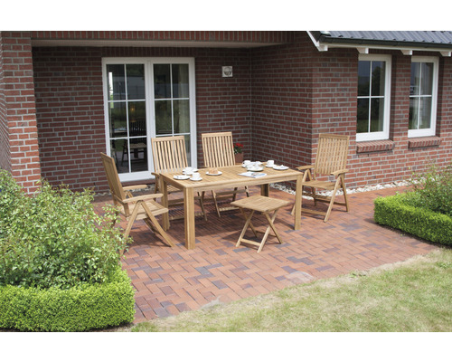 Gartenszene mit Teakholzmöbeln, bestehend aus Tisch, Stühlen und Hocker, arrangiert auf einer Terrasse vor einem Backsteinhaus