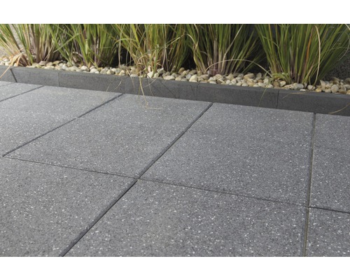 Graue Terrassenplatten aus Beton mit Rasenkante und Zierkies