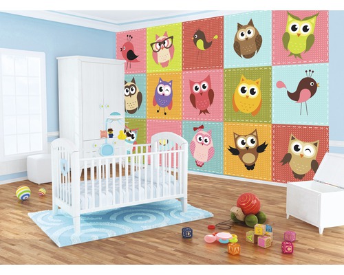 Kinderzimmer mit Kinderbett, Schrank und einer Tapete mit Eulenmotiven