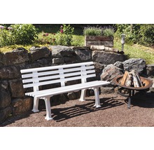 Gartenszene mit einer weißen Gartenbank aus Holz und einer Feuerstelle aus Metall.