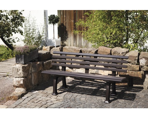 Metall Gartenbank vor einer Steinmauer