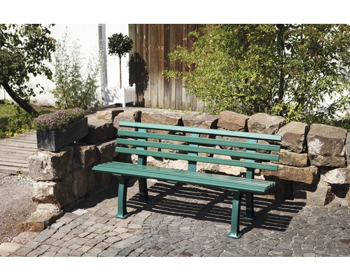 Gartenbank aus Metall vor einer Steinmauer