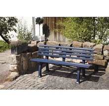 Eine Gartenbank aus Metall steht auf einem gepflasterten Platz in einem Garten.