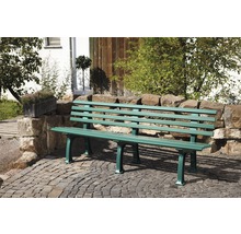 Gartenbank aus Metall vor einer Steinmauer