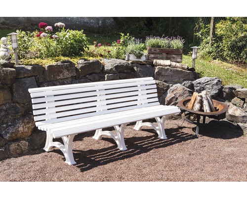 Gartenlandschaft mit weißer Bank, Feuerstelle und Steinmauer