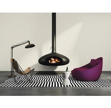 Wohnzimmer mit hängendem Kamin, Sessel und Stehlampe auf einem schwarz-weiß gestreiften Teppich