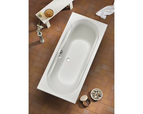 Aufnahme einer rechteckigen Badewanne im Badezimmer mit Fliesenboden und Badaccessoires.